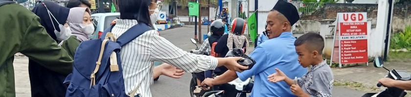 mahasiswa Teknik Industri ITN Malang memberikan bungkusan berisi makanan ke pengendara sepeda motor