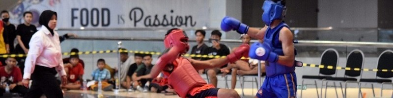 Ibnu Rossie Adiyo atlet wushu ITN Malang (sudut biru) saat menendang lawannya di Kejuaraan Wushu Sanda SLC Cup 2022
