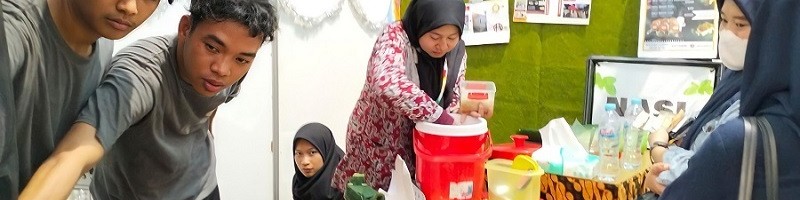 Mahasiswa ITN Malang bersemangat melayani pengunjung membeli nasi bakar di KMI Expo 2022.